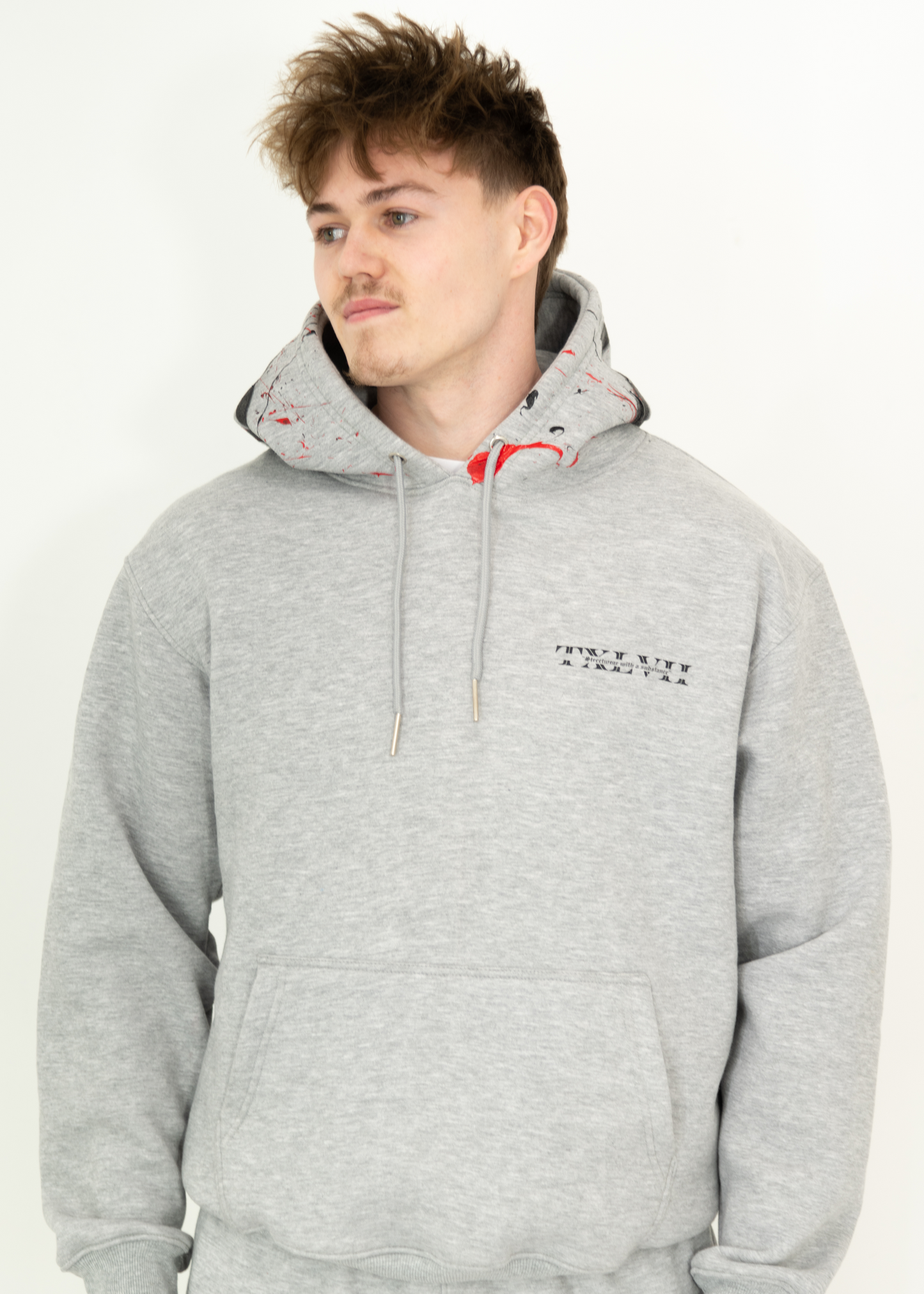 Grey custom-made hoodie worn by a model, designed by brand TXLVII and handcrafted in Newcastle upon Tyne, UK, showcasing premium UK-made streetwear.